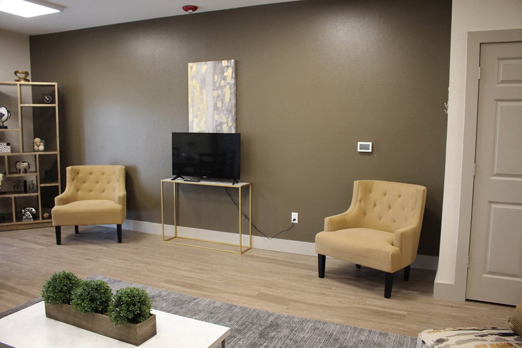a living room with two chairs and a television at Salem Place Apartments, Daleville, 47334