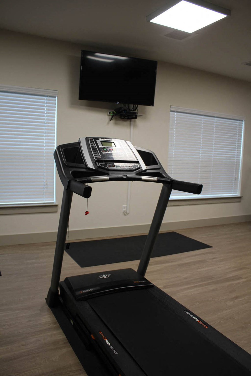 a treadmill in a room with a tv on the wall at Salem Place Apartments, Daleville