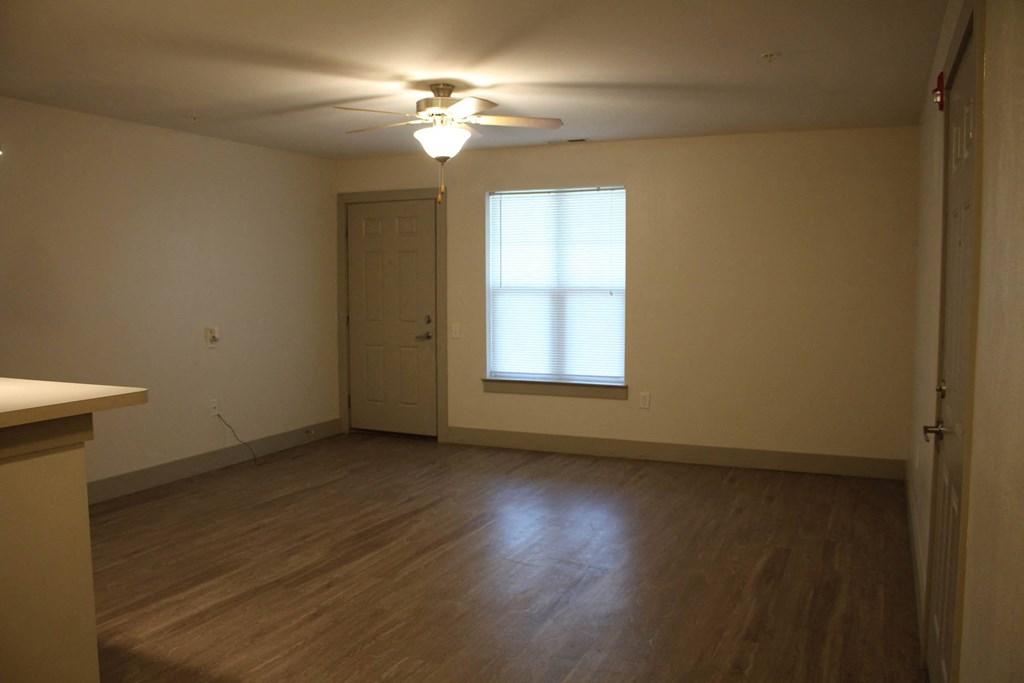 an empty living room with a window and a ceiling fan at Salem Place Apartments, Daleville