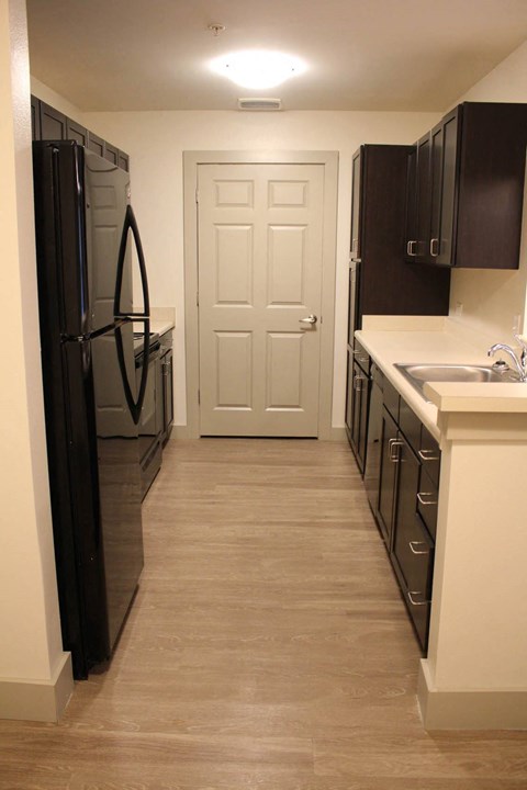 a kitchen with a refrigerator and a sink and a door