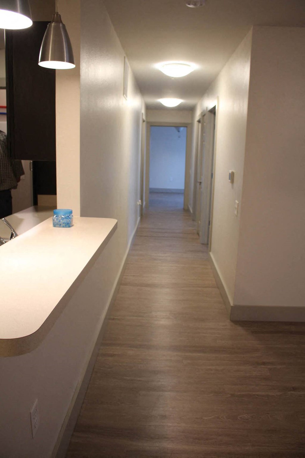 a long white hallway with a counter and a hall way to another room at Salem Place Apartments, Daleville, IN