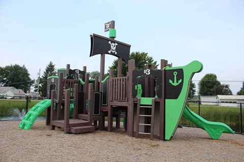 a playground with a mix of wooden structures and green and brown equipment at Salem Place Apartments, Daleville, 47334