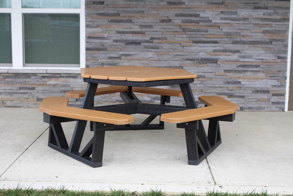 a pair of benches with a table on a sidewalk at Salem Place Apartments, Daleville, Indiana