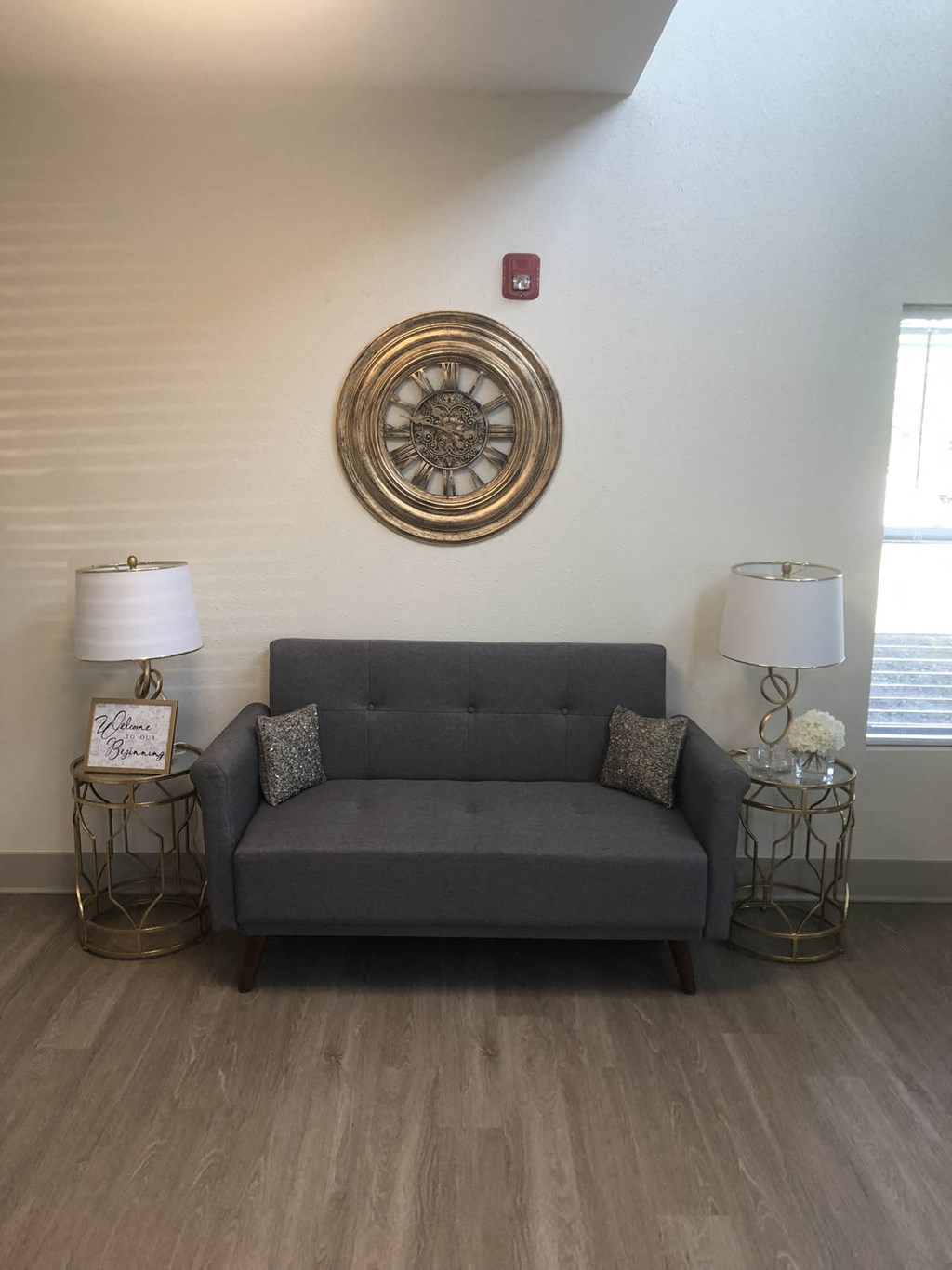a living room with a couch and a clock on the wall