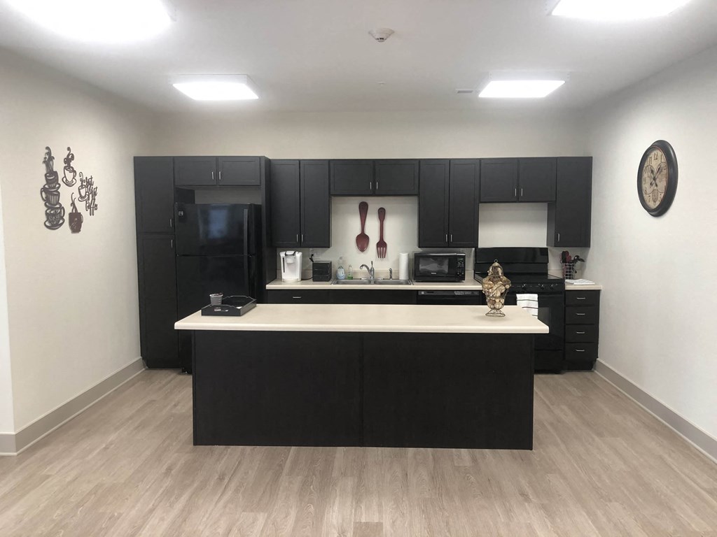 a kitchen with black cabinets and a white counter top
