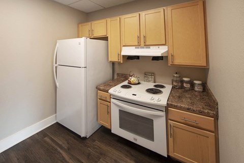 a kitchen with a white stove and refrigerator