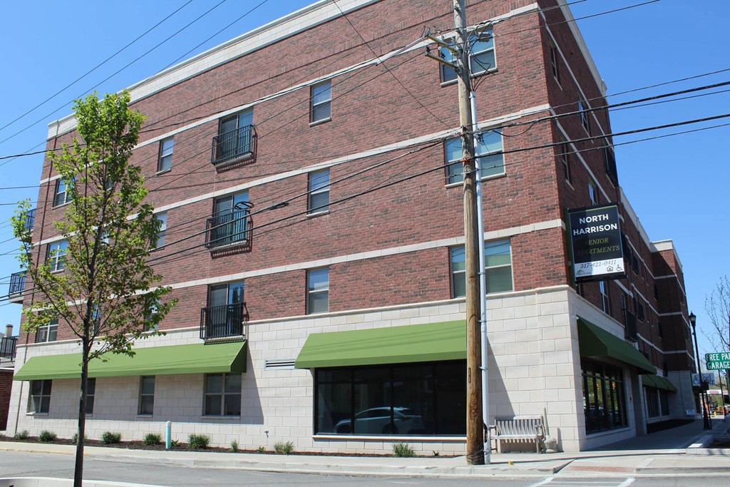 a brick building with a green awning on the side of it  at North Harrison Senior Apts, Shelbyville, IN, 46176