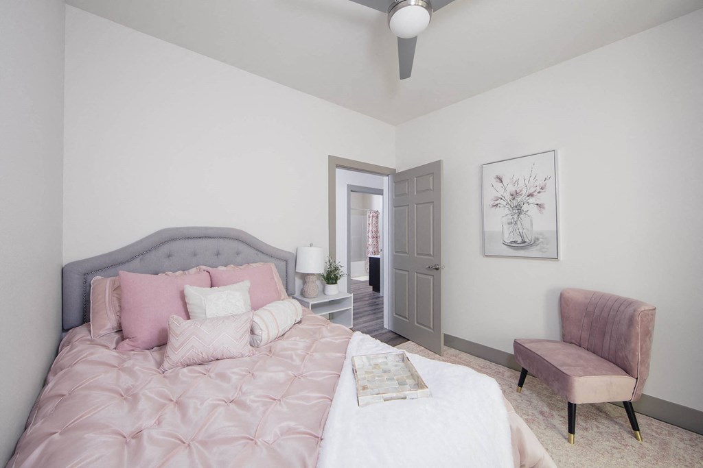 a bedroom with a bed and a chair and a door to a bathroom at Ritchey Reserve, Fishers, IN