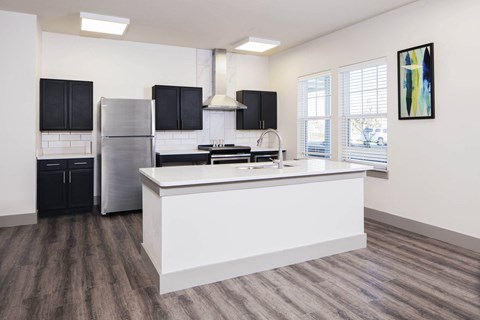 a kitchen with a large island and a stainless steel refrigerator