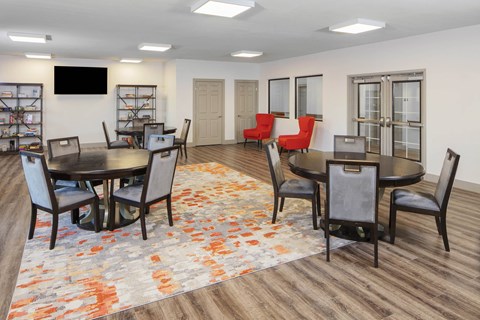a community room with tables and chairs and a tv at Ritchey Reserve, Fishers