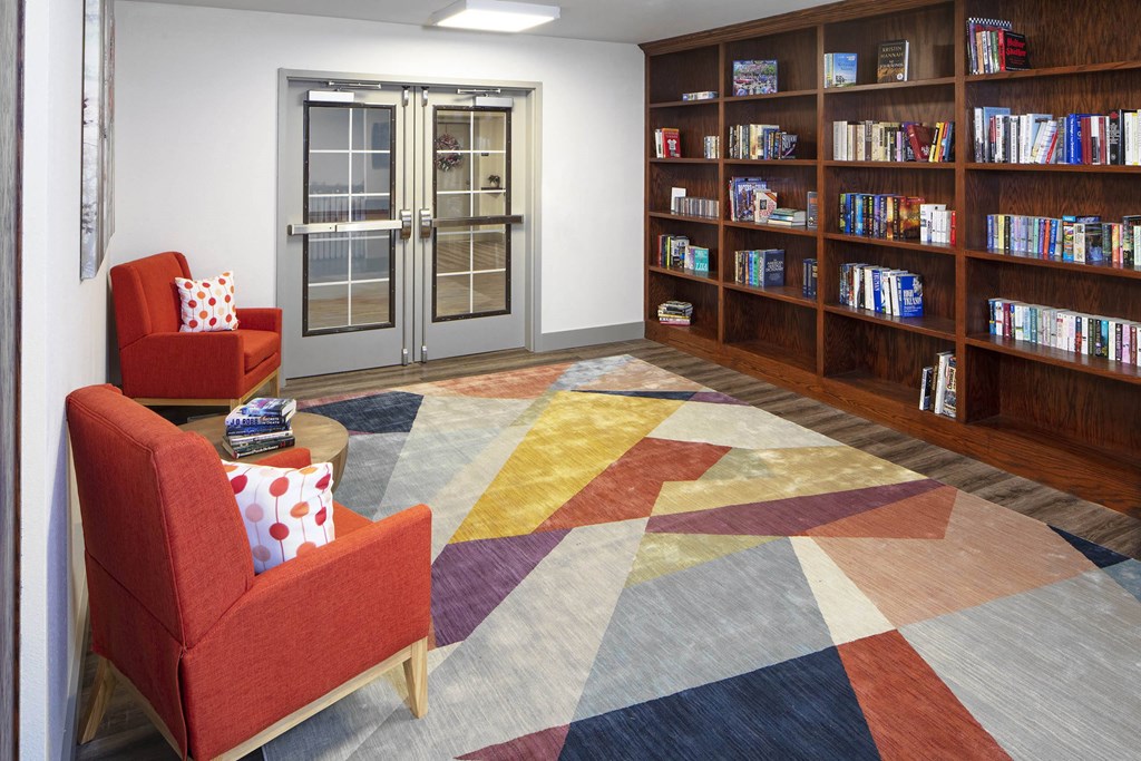 a library with red chairs and a colorful rug at Ritchey Reserve, Fishers, IN, 46038