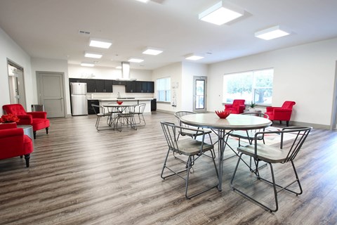 a dining room with tables and chairs and a kitchen