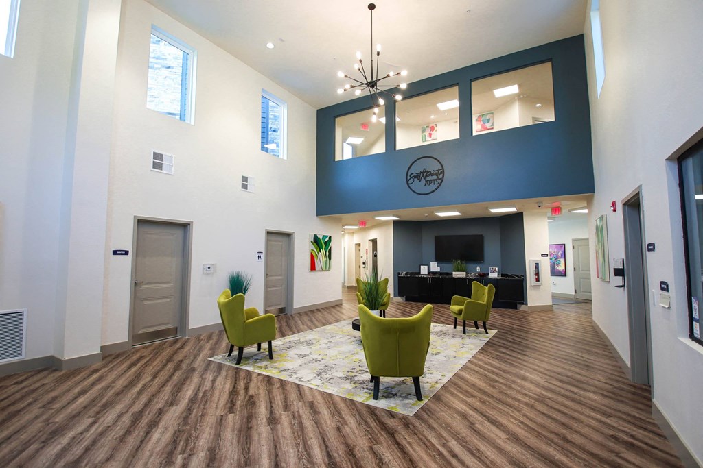 a large lobby with chairs and a table and a large clock on the wall at SouthPointe Village Apartments, LP, Indiana, 46038