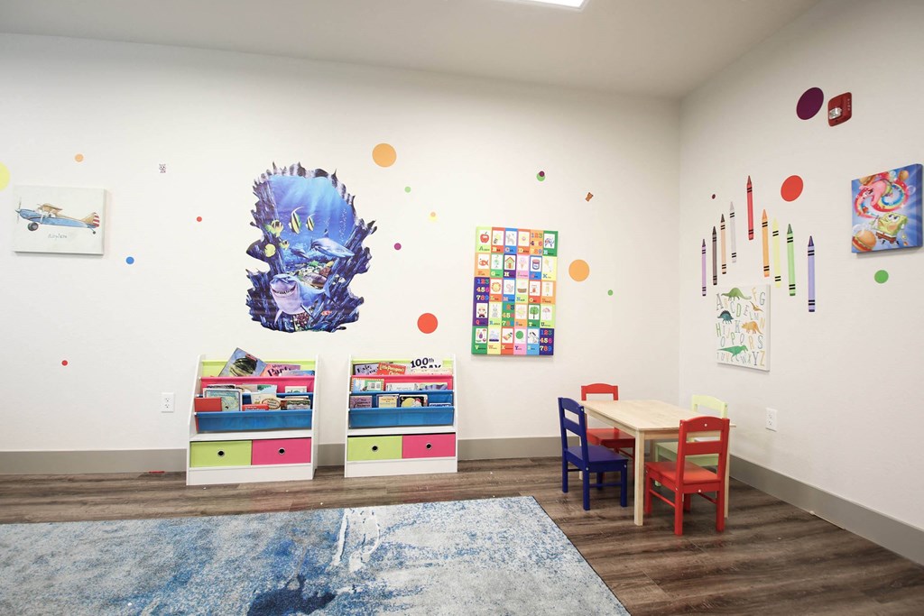 a play room with a table and chairs and paintings on the wall at SouthPointe Village Apartments, LP, Fishers, Indiana
