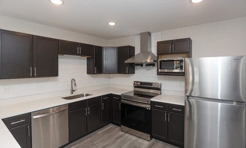 a kitchen with stainless steel appliances and black cabinets