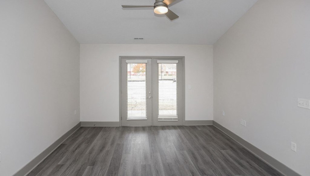the living room of an empty house with white walls and wood floors