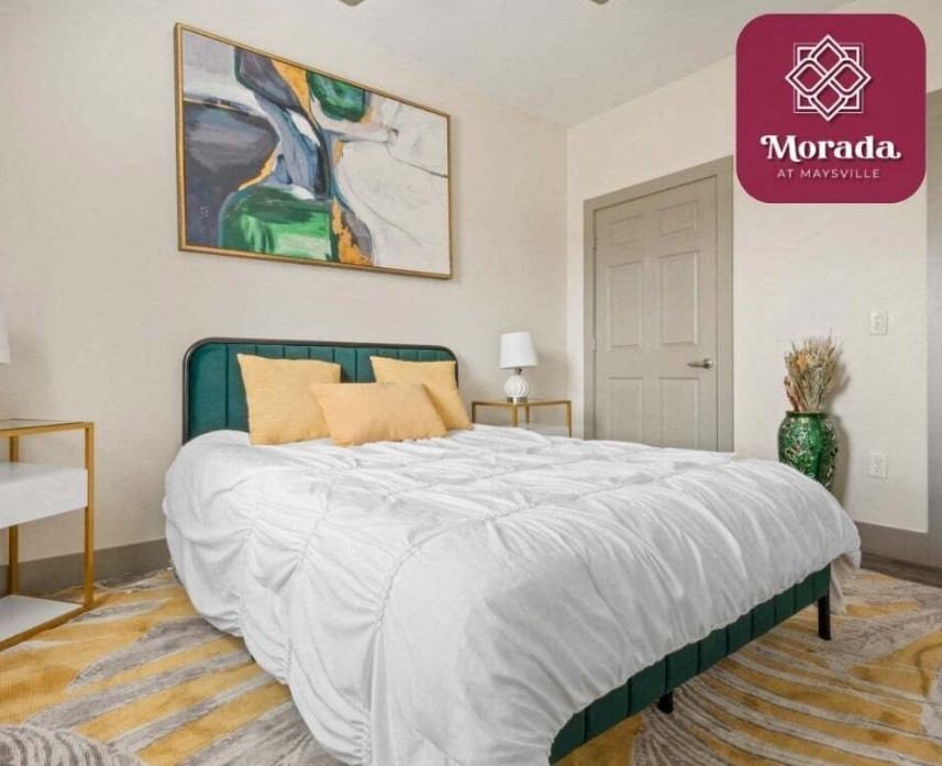 a bedroom with a bed and a painting on the wall