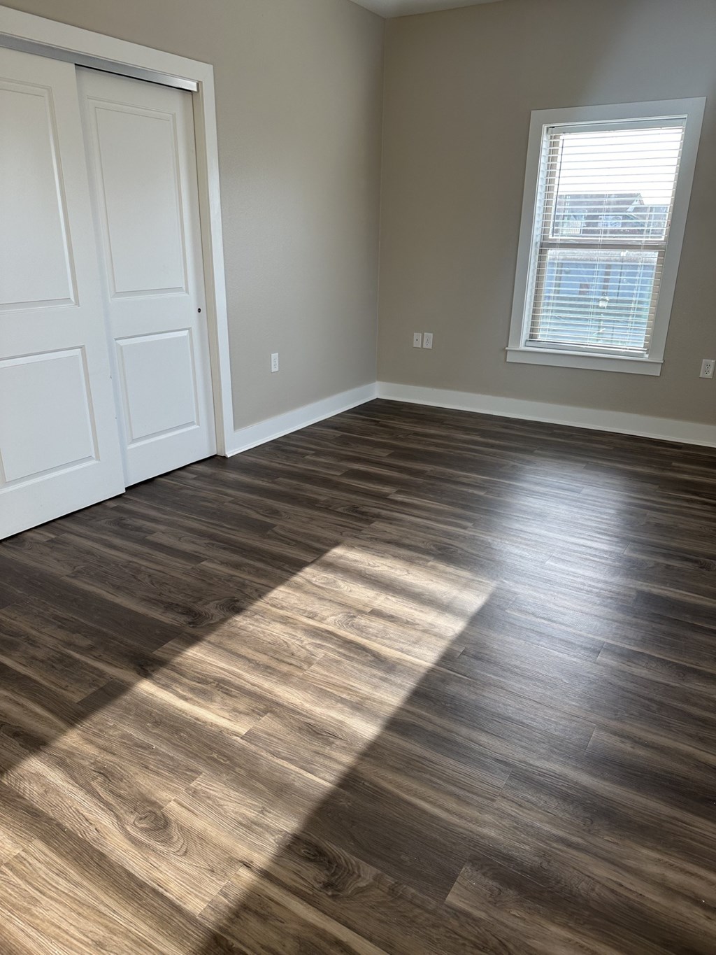 A room with a wooden floor and a white door.
