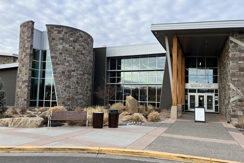 A modern building with a stone facade and large glass windows.