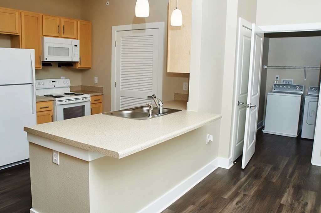 A kitchen with a white fridge, microwave, and stove.