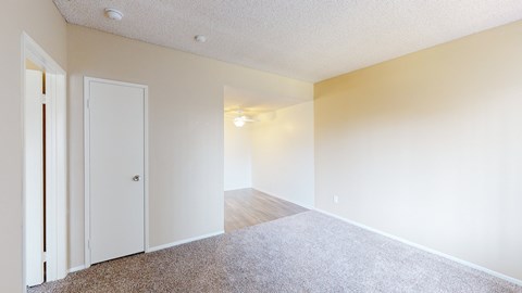 A room with a carpeted floor and a white door.