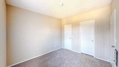 A room with carpeted floor and white doors.