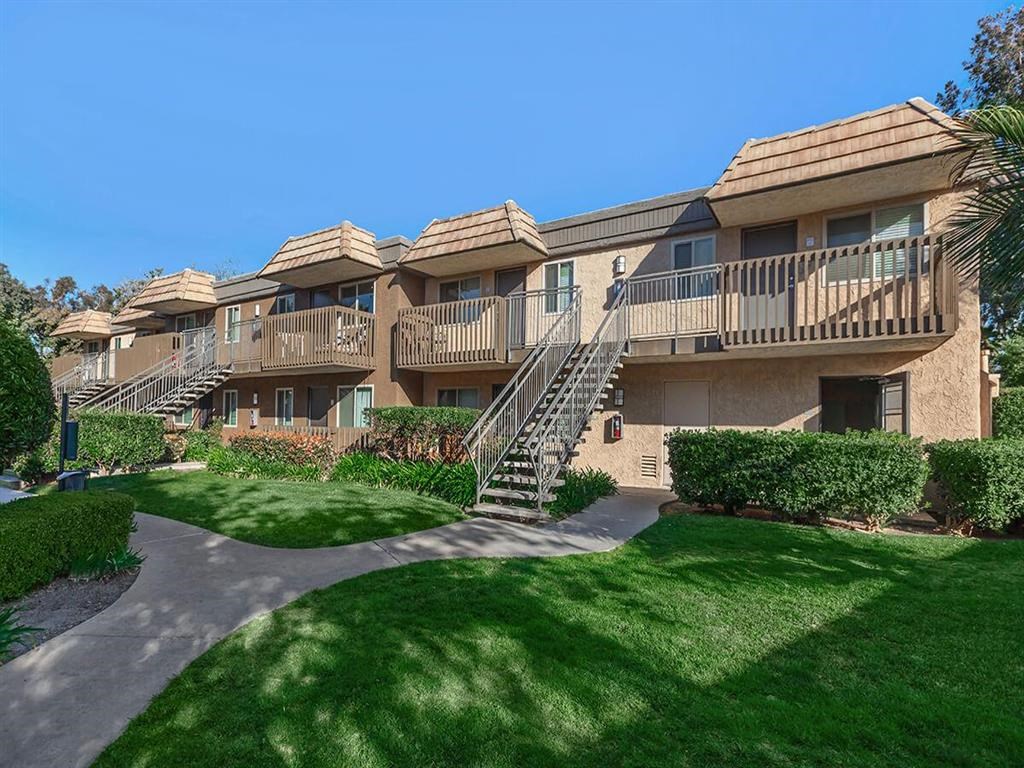 an apartment building with stairs and green grass