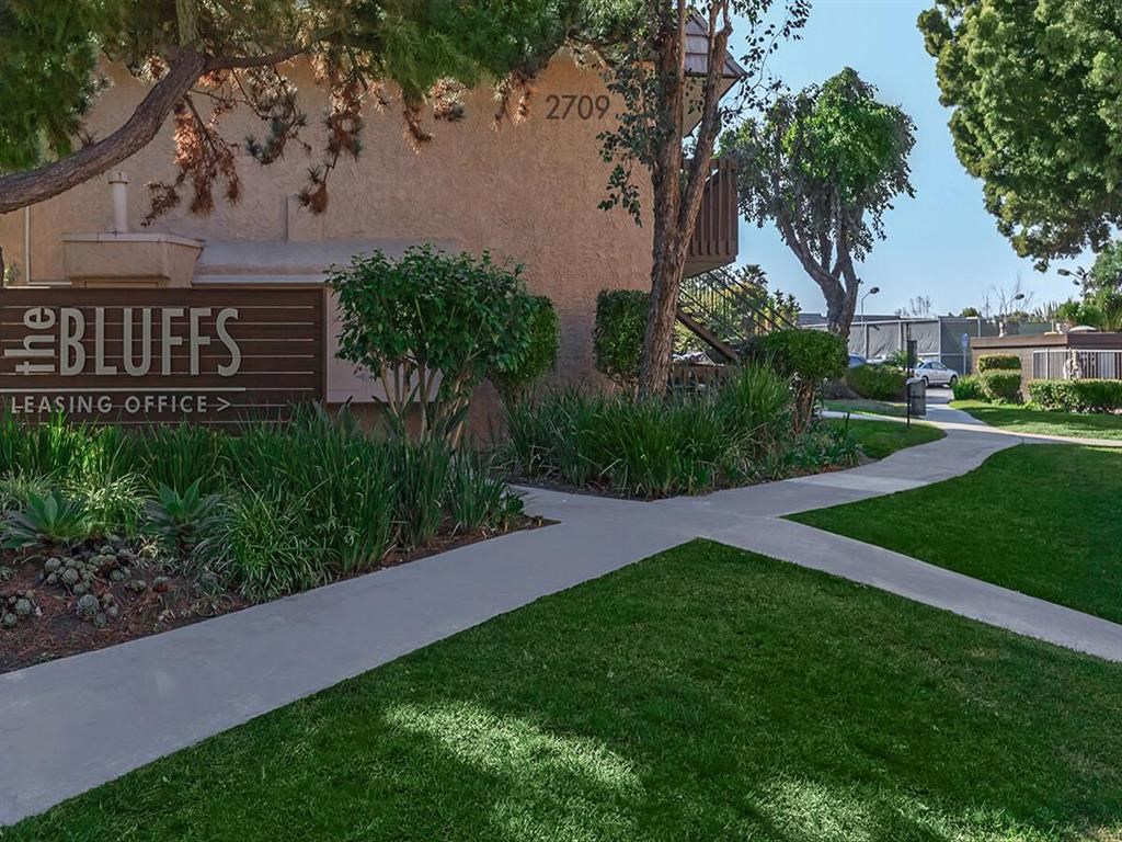a sidewalk in front of a building with a sign for the blues eating office