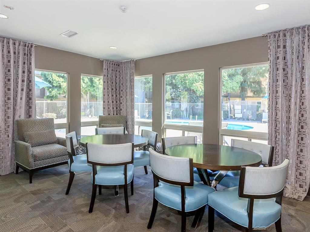 a dining room with a table and chairs and windows