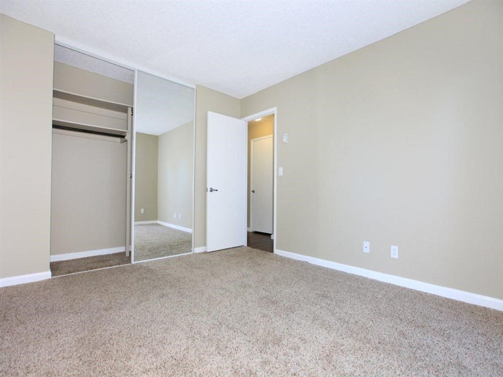 an empty living room with a door to a closet