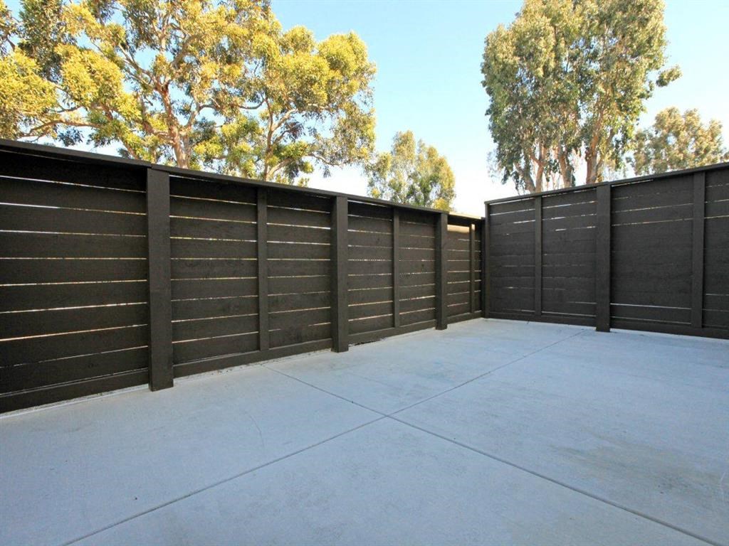 the backyard of a house with a black fence