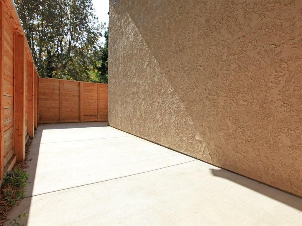 a yard with a concrete wall and a wooden fence