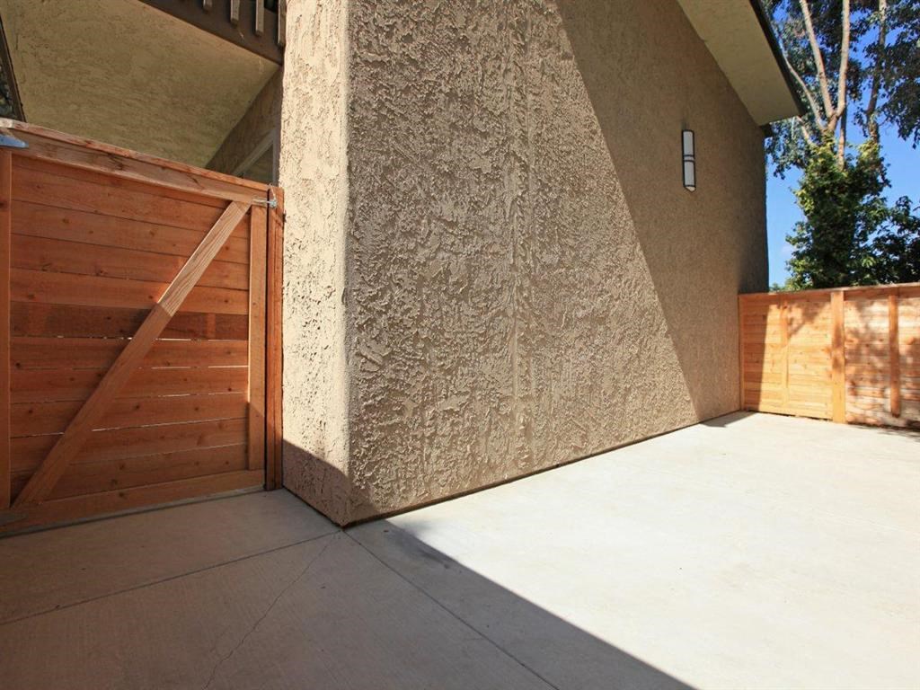 a porch with a wooden fence and a concrete floor