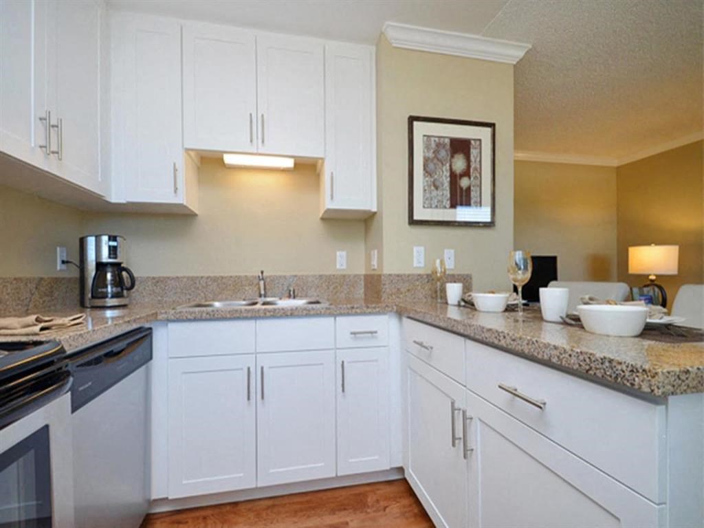 a kitchen with white cabinets and granite counter tops