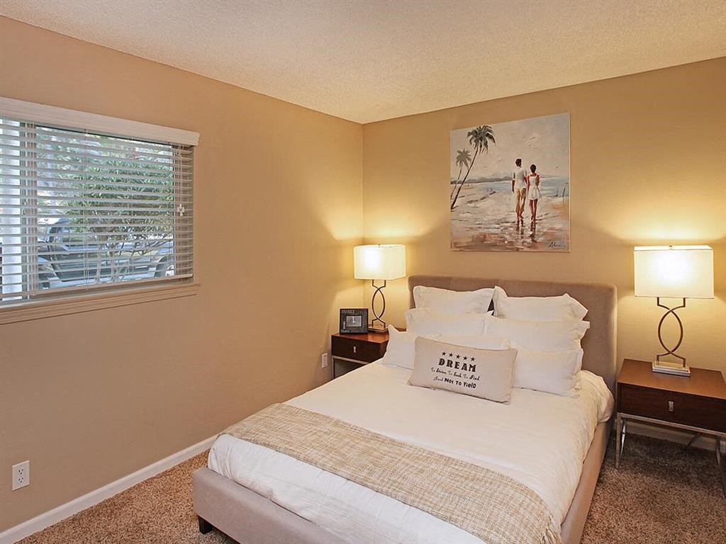 a bedroom with a bed and two lamps