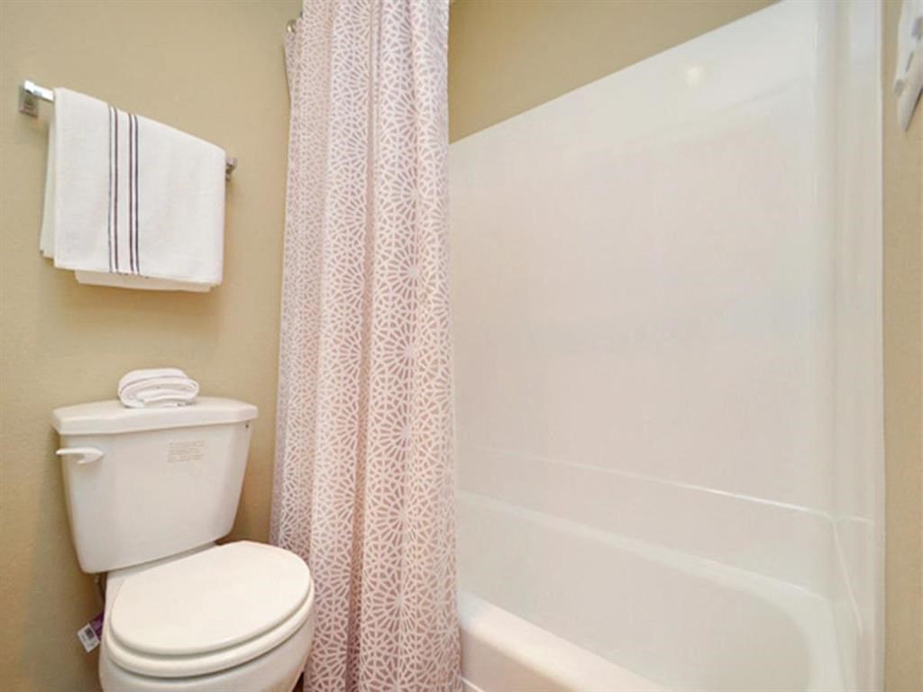 a bathroom with a toilet and a tub and a shower curtain