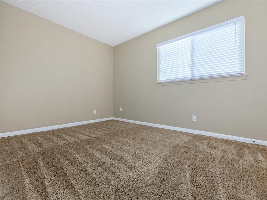 an empty room with carpet and a window