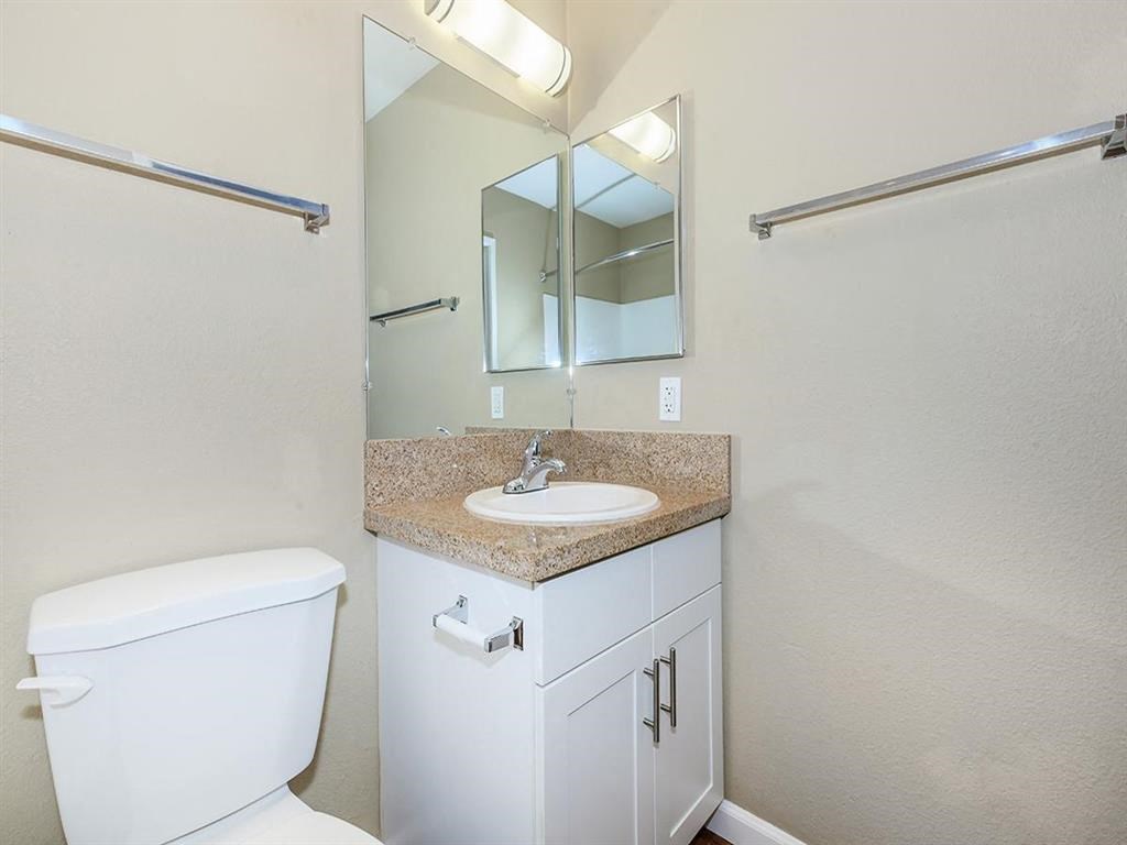 a bathroom with a sink toilet and a mirror