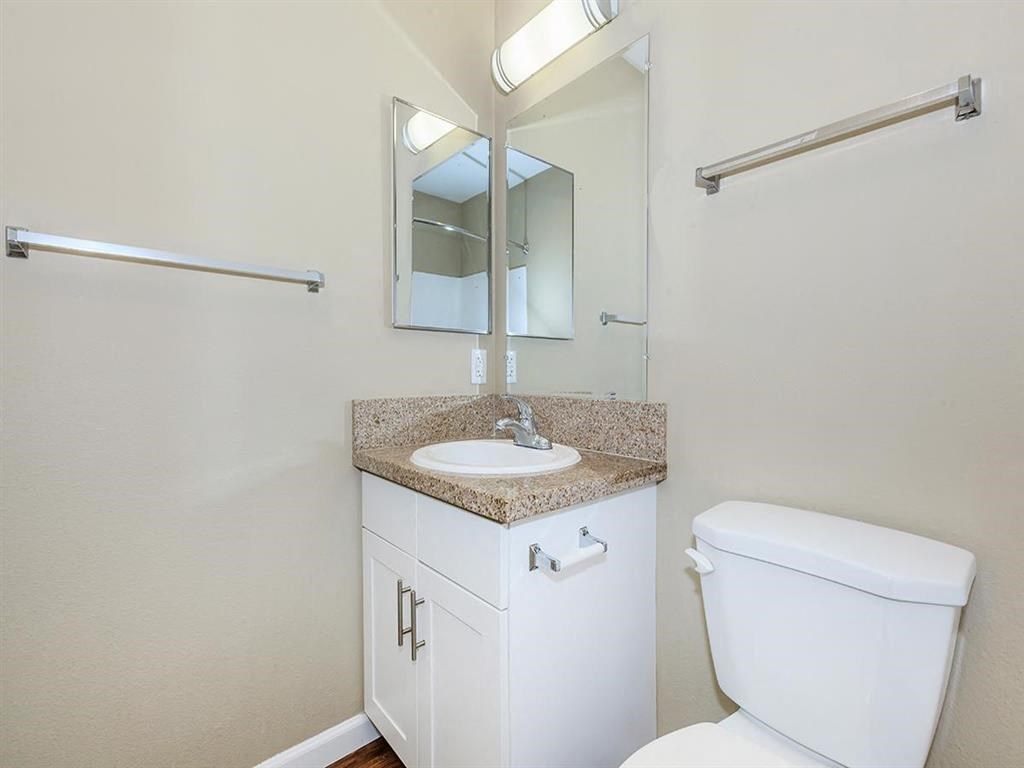 a bathroom with a toilet sink and a mirror