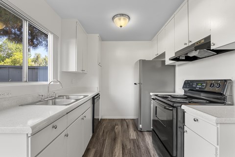A modern kitchen with white cabinets and stainless steel appliances.