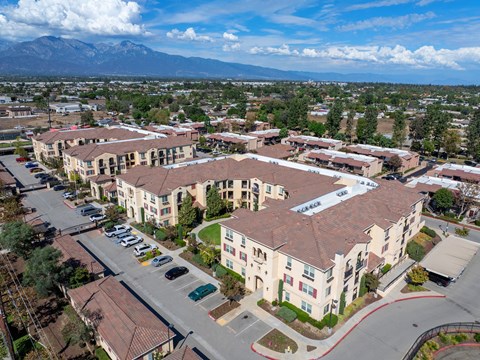 A large apartment complex with a parking lot in front.
