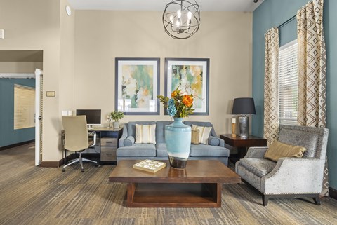 A living room with a brown carpet and a grey couch.