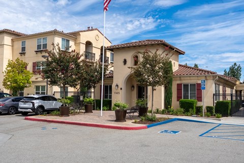 A building with a flag on top and a car parked in front.