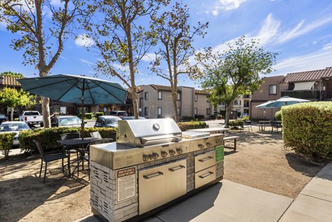 A BBQ grill is in the middle of a courtyard.