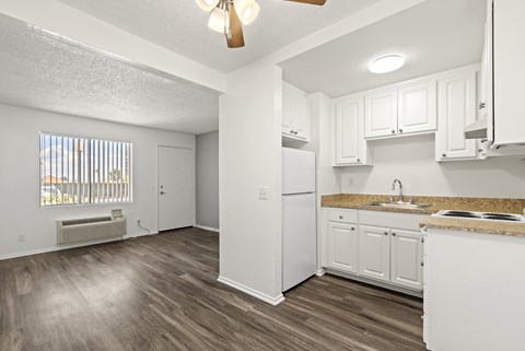 A kitchen with white cabinets and a white refrigerator.