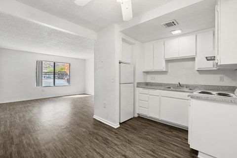 A kitchen with white cabinets and a refrigerator.