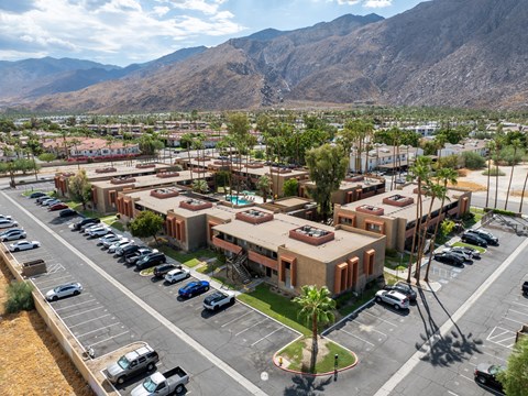 A parking lot with cars and a building in the background.