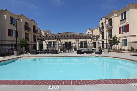 A swimming pool in front of apartment buildings.