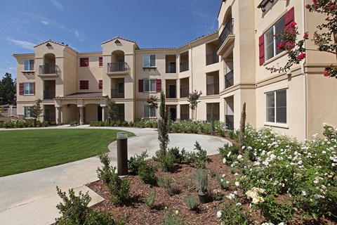 A building with a well-maintained garden in front.