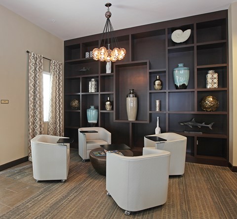 A living room with a brown carpet and a white chair.